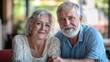 © Naknakhone - A smiling older couple sits together at a table, radiating warmth and affection in a cozy, well-lit environment.