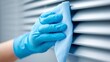 © Evodigger - Person's gloved hand using clean microfiber cloth to gently wipe louvers of air conditioner vent