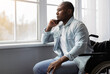 © Prostock-studio - Lonely disabled person at home or rehabilitation clinic during COVID-19 lockdown. Melancholic adult african american man in wheelchair looking at window and dreaming, in living room interior, profile