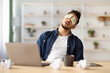 © Prostock-studio - Tired arab guy with open eyes drawing on his face sleeping at workdesk with laptop and mug in office, copy space. Exhausted middle-eastern man experiencing burnout at job, lack of ideas