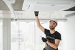 © Serhii - Worker repairing ceiling air conditioning unit