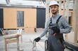 © Serhii - Portrait of worker in uniform near prefabricated wooden house