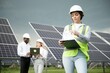© Serhii - Male and female engineers worker working in solar panels power farm. technician working at solar power station