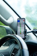 © Irina Mikhailichenko - The map on the phone in the background of the dashboard and street. Black mobile phone with map GPS navigation fixed in the mounting. copy space. High quality vertical photo