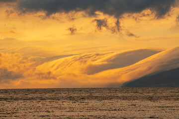 Wall Mural - Beautiful sunset with dramatic clouds over the lake and mountains.
