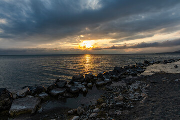 Wall Mural - beautiful sunset with dramatic clouds over the lake and mountains.