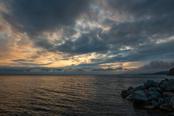 Wall Mural - Beautiful sunset with dramatic clouds over the lake and mountains.