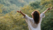 © THESUN - Happy serene woman embracing nature outdoors with open arms in peaceful forest