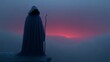 © BOJOShop - Hooded figure holding a staff stands on a rocky ledge during a misty sunrise with pink and blue hues
