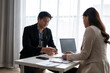 © Apichat - Business people discussing contract and business strategy in office meeting