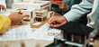 © InfiniteFlow - A vibrant architecture studio scene showing professionals engaged in model building and discussion. Various design sketches and physical models illustrate creative processes and teamwork. SACTR
