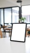 © Rika - Blank tablet screen on a white table in a modern cafe.