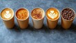 © MBRAMO - Row of takeaway coffee drinks with latte art, on dark stone background. Possible use stock photography