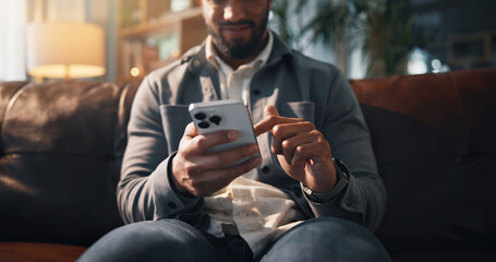 Sofa, phone and hands of man scroll on social media, online connection and text message on weekend. Living room, relaxing and person on smartphone for website, contact and communication in home