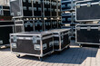 © K - Pile of rugged black touring cases with metal edges, protective equipment boxes for stage gear transport, live concert and festival production storage system, backstage event logistics infrastructure