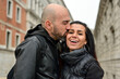 Happy smiling beautiful  Tourists  couple traveling at   Venice Italy, poses and making photos  in front of    bridge of sighs in Venice  .Concept of Italian gastronomy and travel. Italian couple 
