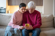© DimaBerlin - Concerned elderly couple checking smartphone on couch. Seniors read suspicious message, husband wife phone scam victim, online fraud, stress from message, risk digital security concerns for seniors