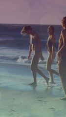 Wall Mural - animation of glowing lights over group of diverse female friends by the sea