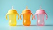© Pete - Three colorful baby sippy cups stand in row on soft blue background. Plastic bottles with handles for drinking, eating, weaning. Stylish design. Vibrant colours yellow, orange, pink for toddler