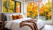© Марина Каліш - Cozy bedroom with a large window showing autumn trees with vibrant yellow and orange leaves, a blanket and pillows on the bed.