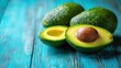 © khumthong - Fresh Ripe Avocados on Rustic Blue Wooden Background Halved Avocado Close Up Healthy Food
