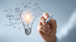 © buraratn - Light bulb symbolizing creativity and innovation, with sketches of ideas and concepts surrounding it, representing inspiration and brainstorming in modern workspace