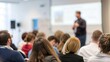 © N7 - Conference audience watching intently — out-of-focus speaker giving presentation