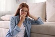 © New Africa - Teenage girl suffering from panic attack leaning on sofa at home