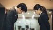 © Mykola - Apologize Business. Adult Asian Businessman and Woman Bowing in Formal Suits at Office
