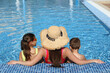 © New Africa - Woman with her children in swimming pool, back view. Summer vacation