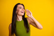 © deagreez - Attractive young woman in green outfit posing on vibrant yellow background expressing happiness and engaging gestures