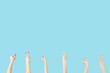 © Pixel-Shot - Female hands showing peace gestures and holding something on blue background