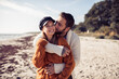 © Davor - Happy couple hugging on beach in autumn clothes
