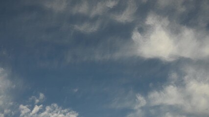 Wall Mural - Time lapse of puffy white summer clouds drifting across  pale blue sky