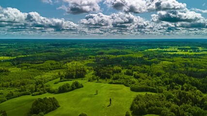 Wall Mural - Clouds casting shadows over hills, fields, and dense forest terrain, aerial hyperlapse on bright day