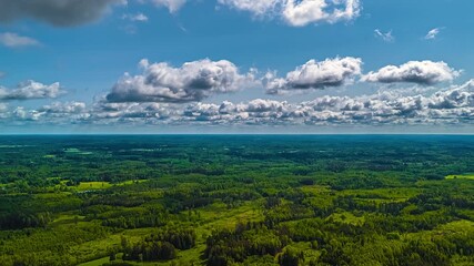 Wall Mural - Cloud shadows drifting across green forests and wide open farmland, static high panoramic overview of climate changing and clouds swirling