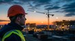© Nasim - Construction worker looking at building site at dusk