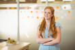 © WavebreakMediaMicro - Businesswoman standing with arms crossed in office by glass partition with sticky notes and bananas