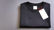 © HiraStock - Folded Black T Shirt With Blank Tag On Gray Background For Mockup
