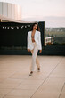 © Darius - Model walking elegantly on rooftop during sunset wearing stylish outfit
