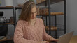 © Krakenimages.com - Young woman focused on computer work in a cozy indoor office space with shelves and modern decor around, reflecting a productive and professional atmosphere.