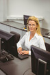 © WavebreakMediaMicro - Woman typing on keyboard at office computer lab desk wearing white shirt among monitors and cables