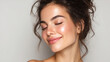 © buraratn - Young woman with glowing skin and joyful expression, showcasing natural beauty and fresh look. Her hair is styled in loose curls, enhancing her radiant appearance