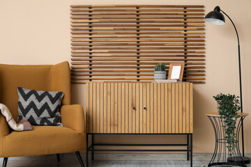 Poster - soft armchair, wooden chest of drawers, lamp and folding screen in interior of beautiful living room