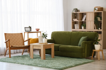 Poster - interior of living room with green sofa, armchair and plants
