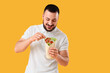 © Pixel-Shot - Young man with tasty sandwich wrap on yellow background