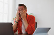 © Tj - Exhausted businessman experiencing eyestrain and suffering from headache after long laptop use, taking break and rubbing tired eyes, having problem with vision after computer work