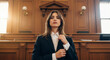 © Milan - Confident young female lawyer in a suit standing in a courtroom. Professional woman attorney preparing for a legal trial.