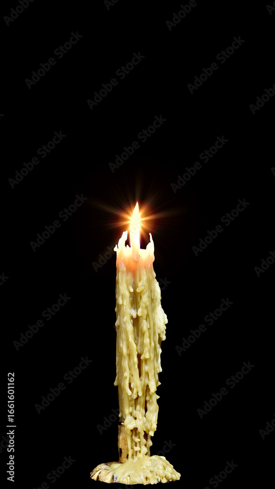 A single burning candle with melted wax drip casting a warm glow ...