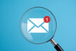 © Janntul - Investigating Low Feedback Email Notifications A Magnifying Glass Focuses on a New Message Icon Against a Light Blue Background for Review